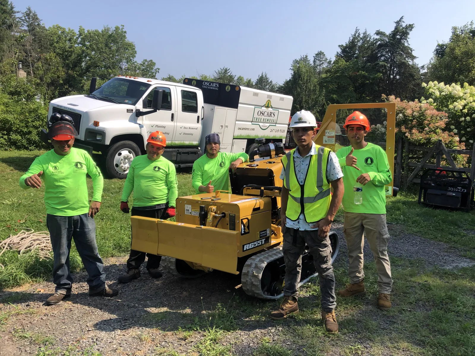 The Oscar's Tree Removal and Stone Veneer crew with their truck and equipment