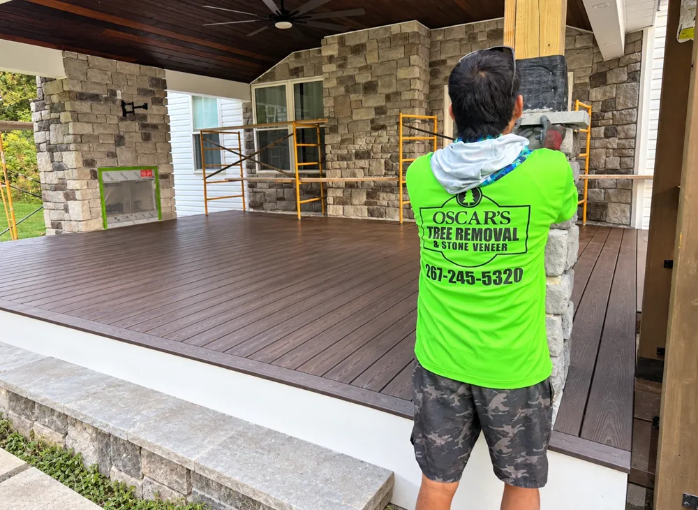 Oscar&rsquo;s Tree Removal and Stone Veneer crew member setting stone