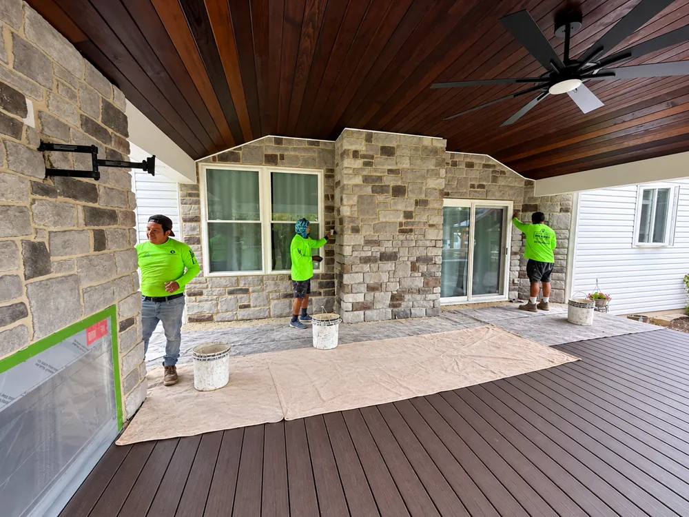 Oscar&rsquo;s crew installing stone veneer across a covered patio