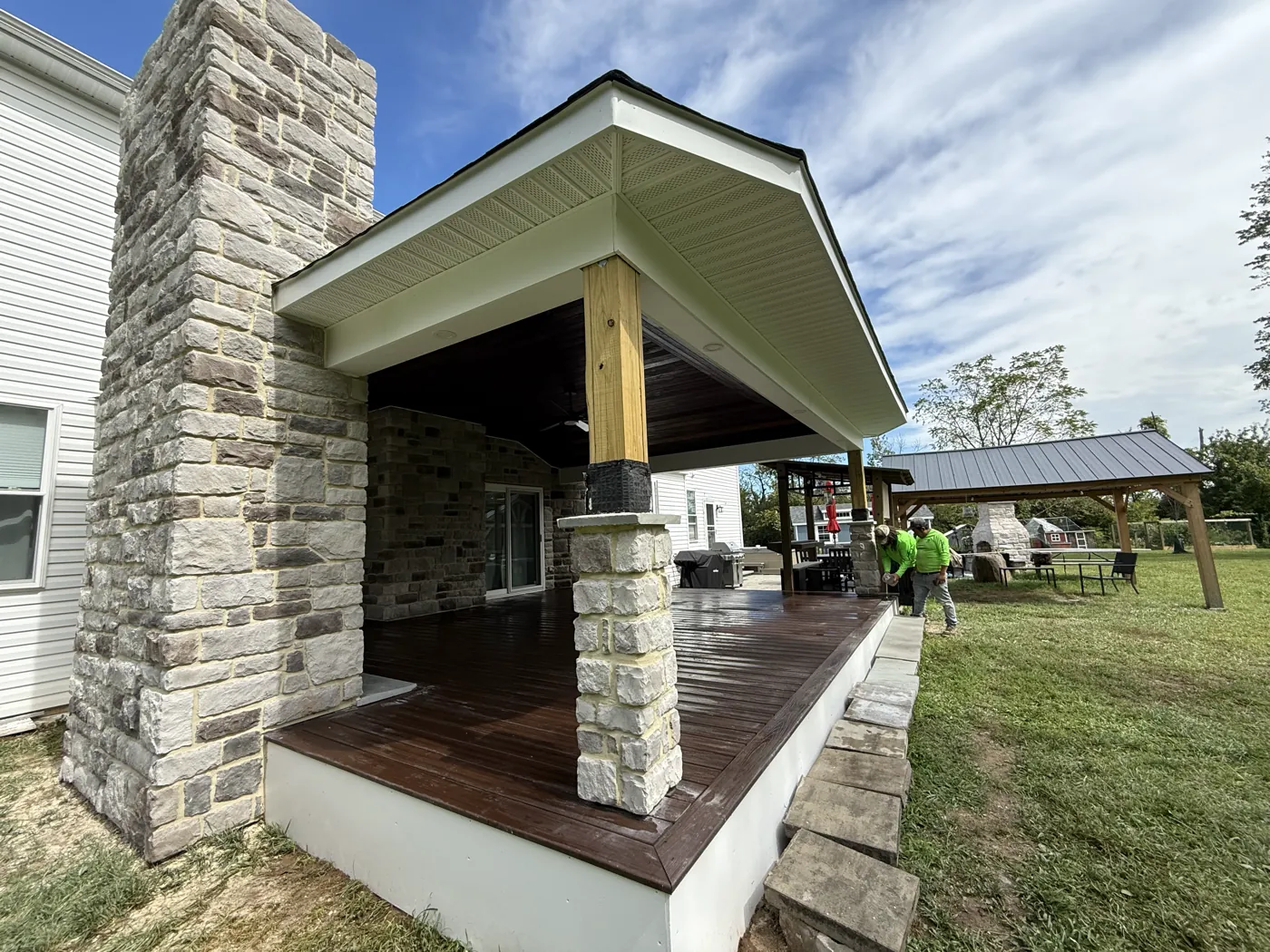 Finished stone veneer chimney and covered patio after installation by Oscar&rsquo;s crew