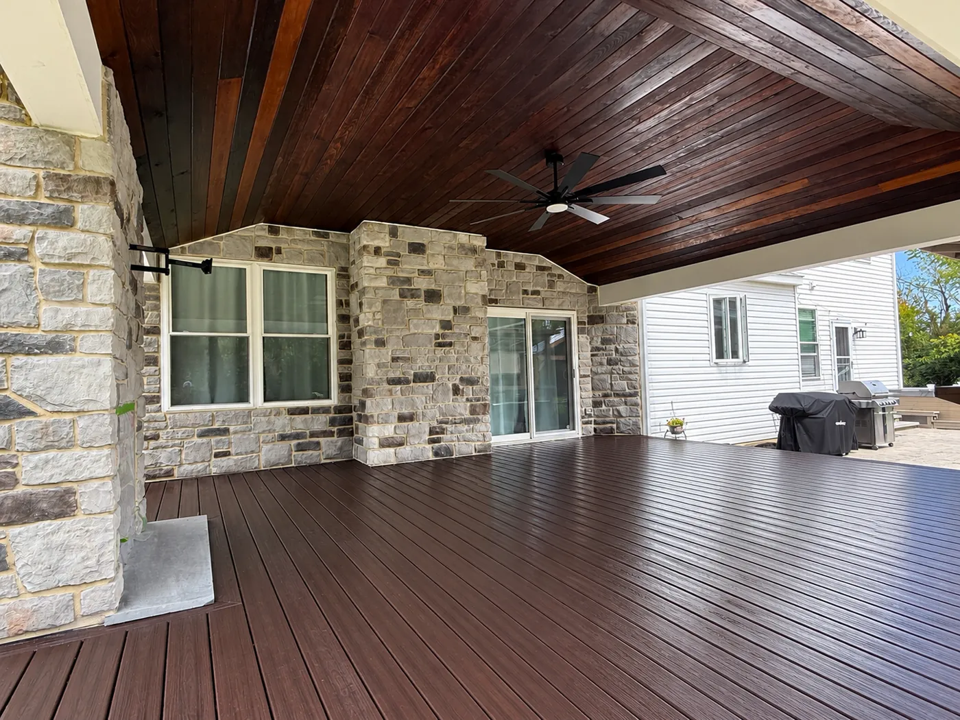 Completed stone veneer walls and columns under a covered patio